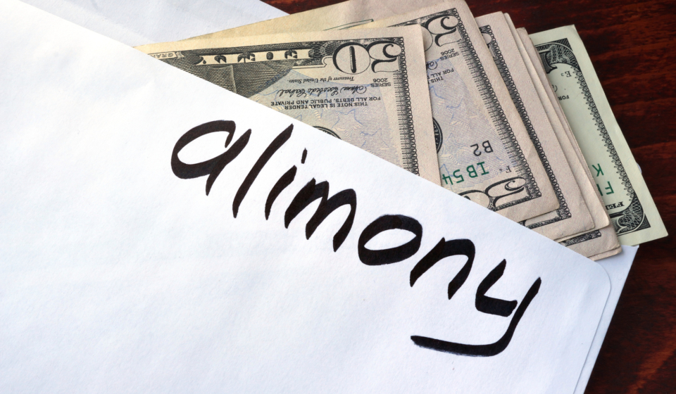 Alimony written on an envelope with dollars.